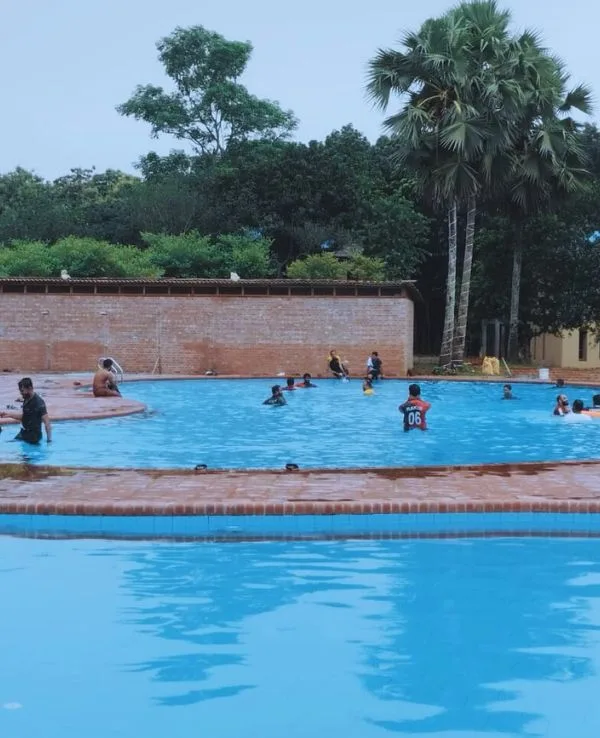 Guests swimming in the pool at the family resort in Gazipur