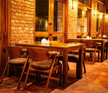 Banglar Rosui restaurant interior with brick walls and wooden tables