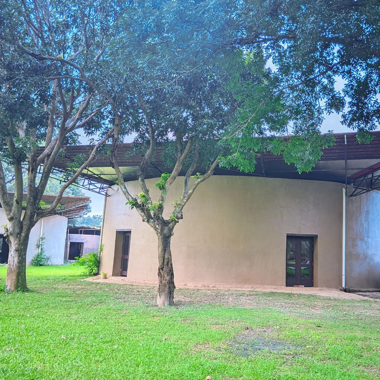 Mud house exterior with tiled roof at Matir Maya Eco Resort, Sreepur