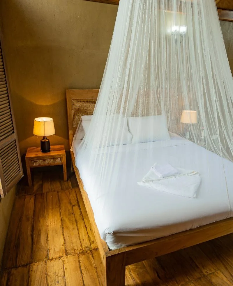 Premium room bed with mosquito canopy at Matir Maya Eco Resort, Gazipur